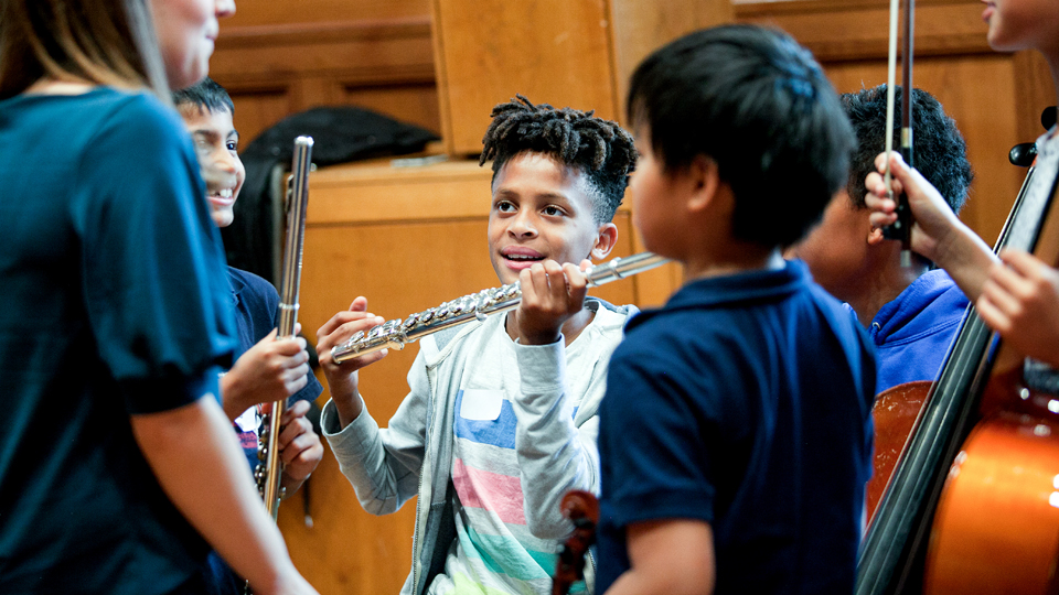 Child playing flute at a Sparks Ignite event
